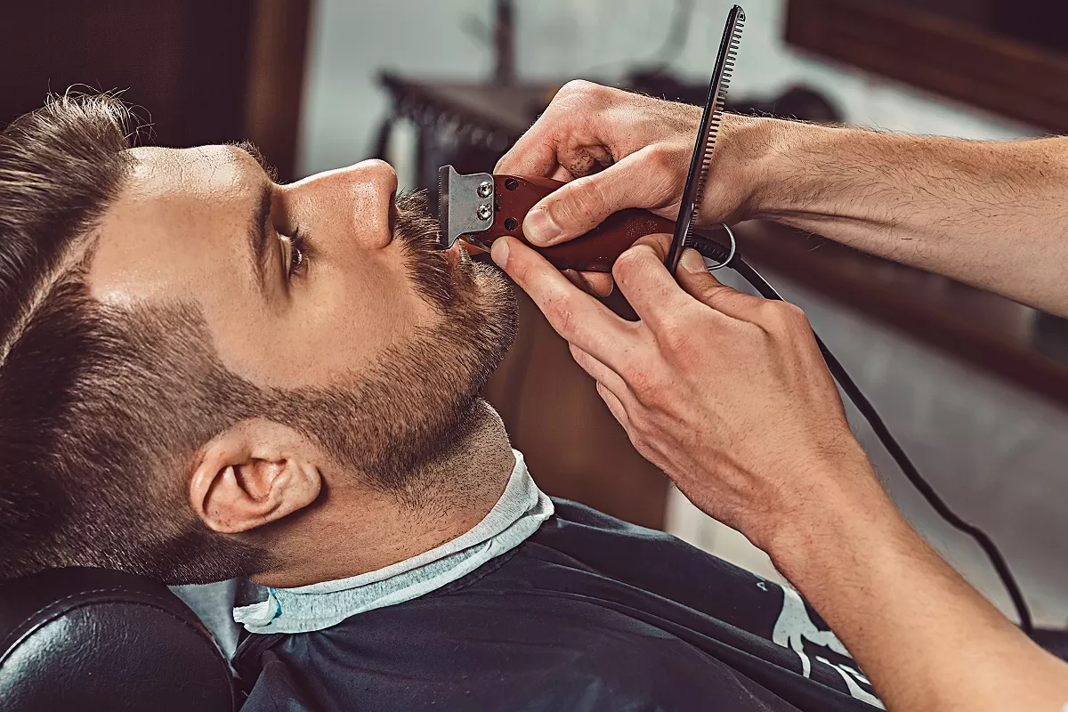 mężczyzna podczas pielęgnacji brody u barbera